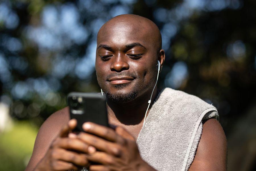 Un homme sourit en regardant son telephone