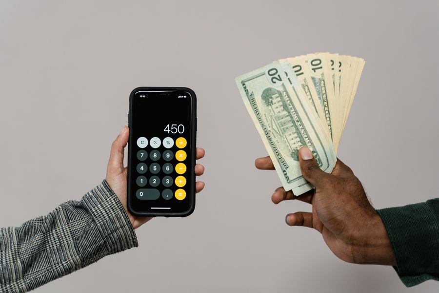 Une main qui tient des billets et un telephone